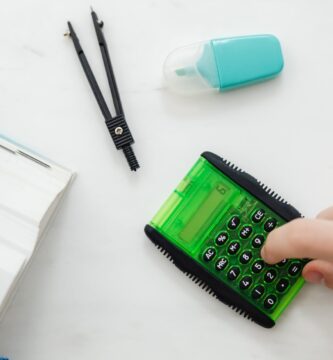 person using a small green and black calculator