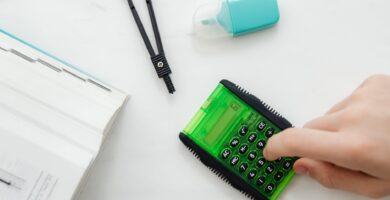 person using a small green and black calculator